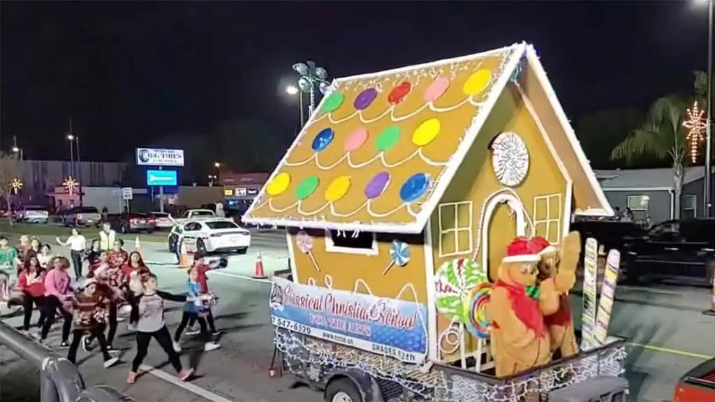 a gingerbread house being carted down a road