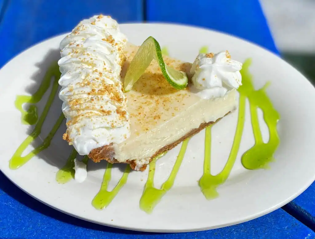 key lime pie on a plate on a blue table.