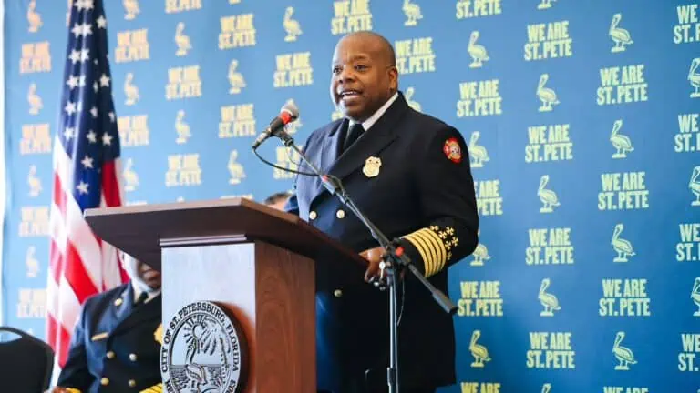 a man stands behind a podium during a press conference