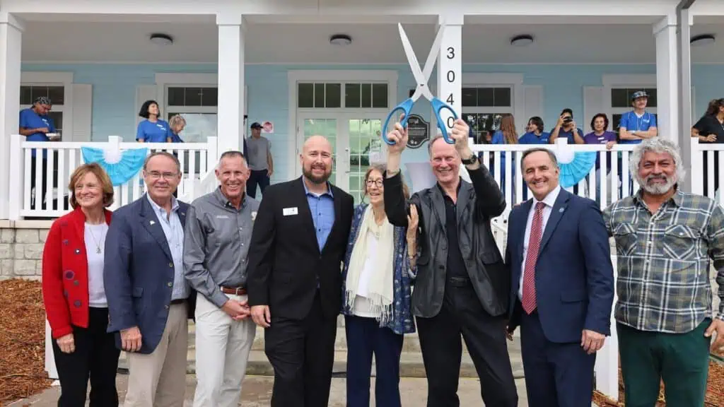 a group of people cut hte ribbon at a new pet adoption center