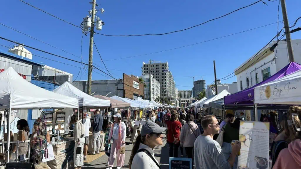 multiple vendor tents set up along and avenue on a sunny day