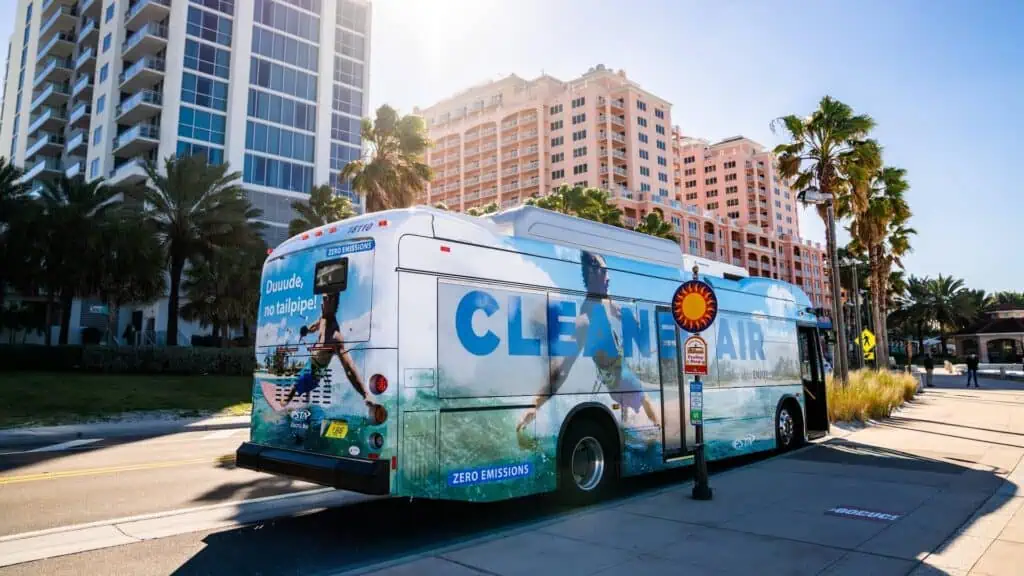 a bus outside with "clean air" written on the side