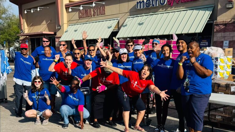 a group of volunteers pose in front of a building