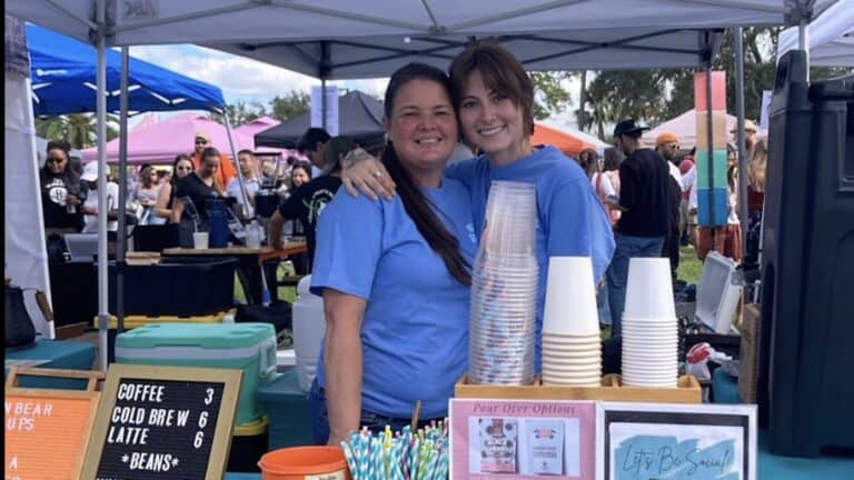 Two people behind a counter at a coffee event