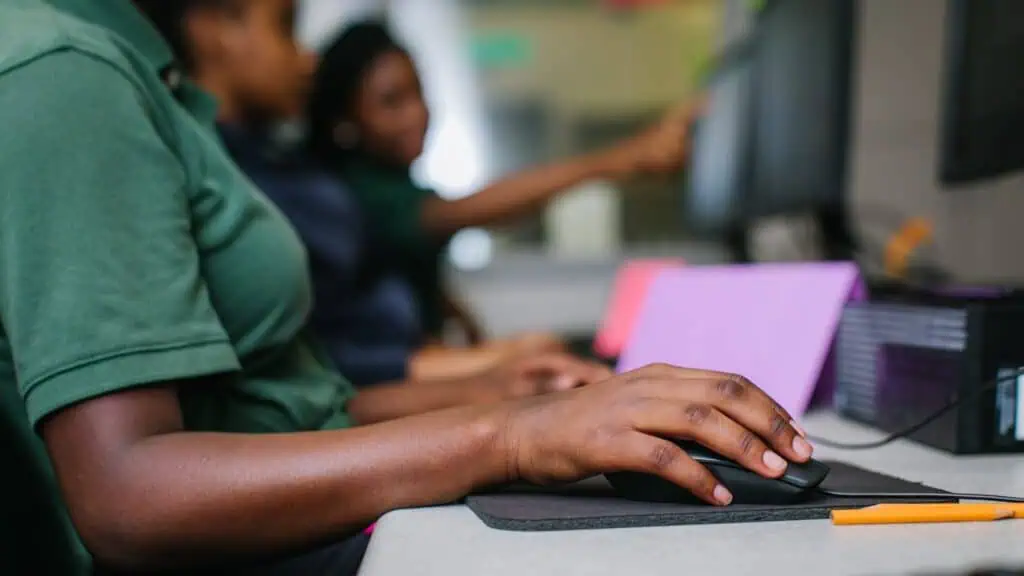 people clicking a mouse in a library computer lab