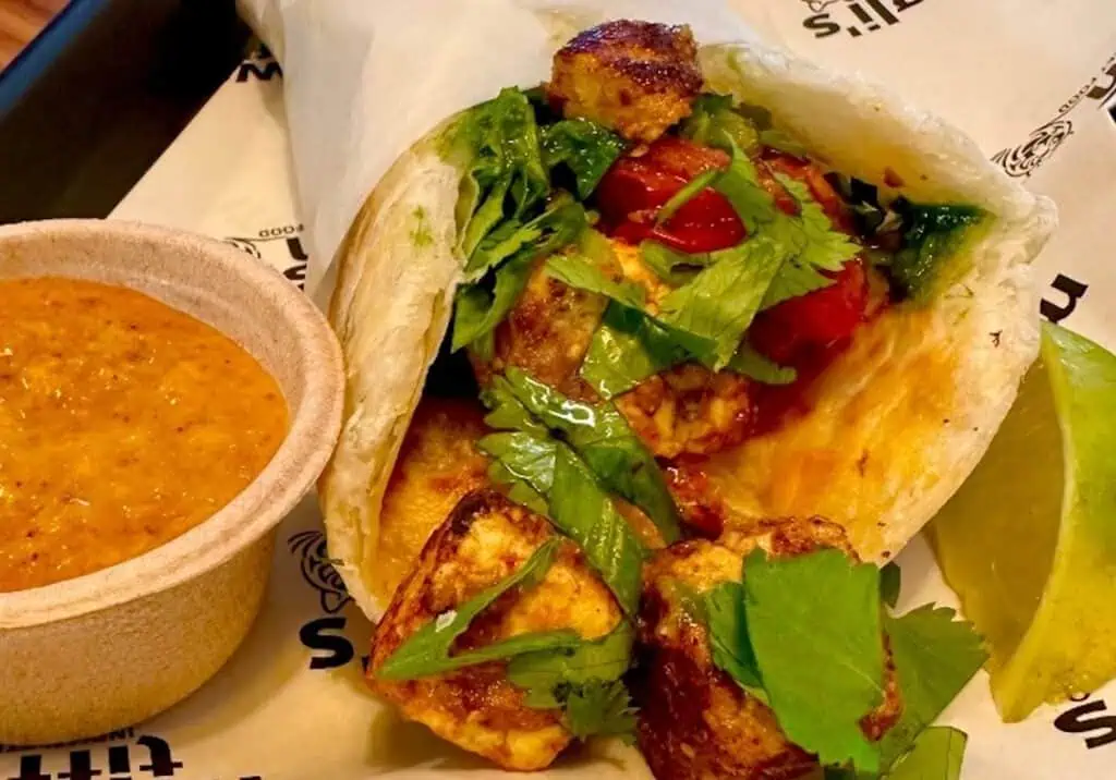 a wrap with marinated chicken and veggies 