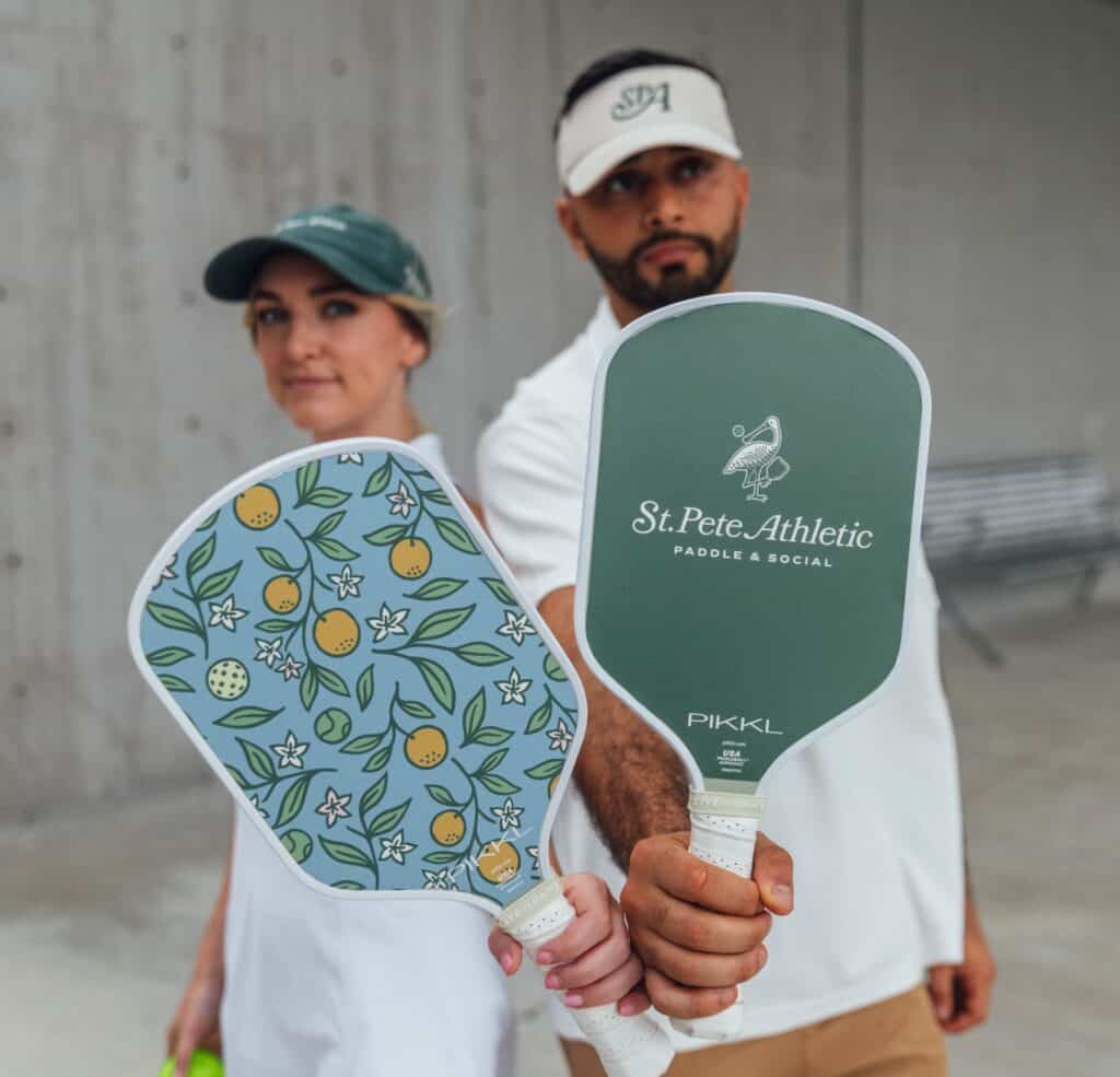 two people holding pickleball paddles 