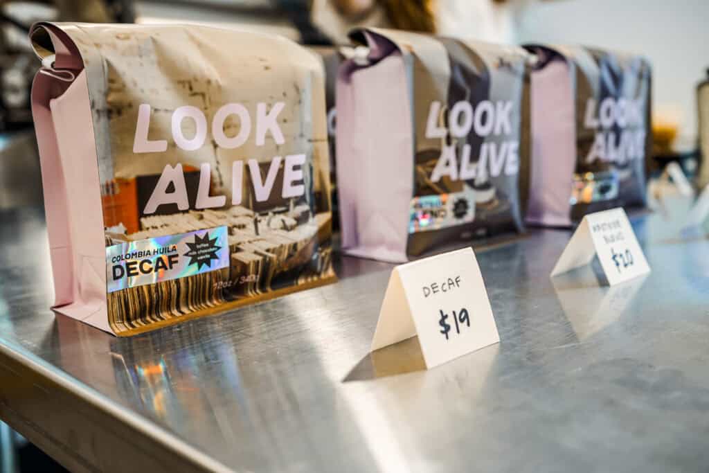 3 bags of coffee on a steel table.