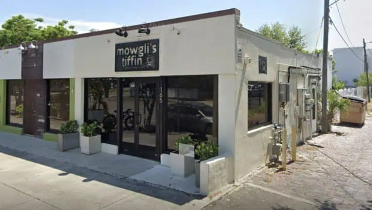 exterior of a restaurant with an iron sign above the front door