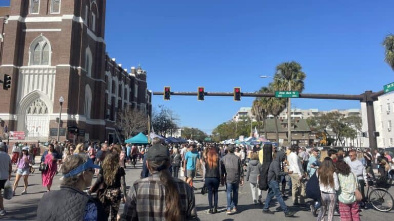 multiple people walking the streets during an outdoor celebration