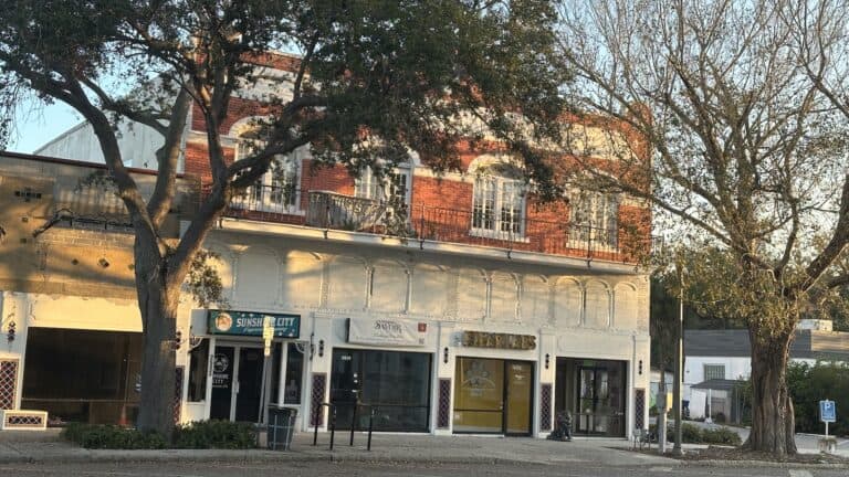 exterior of a building with 3 businesses on the ground floor.