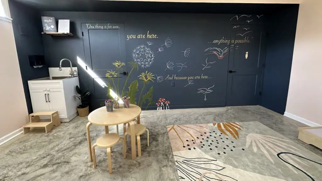 interior of a bookstore with a mural-covered wall facing a small art table for kids