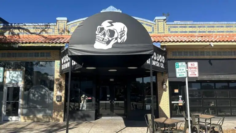 outside a brewery with a black awning with a skull painted on it