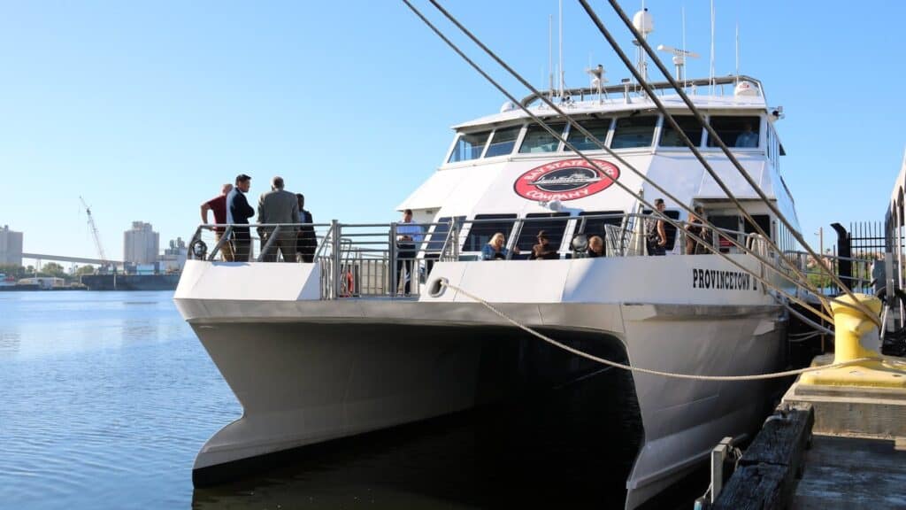 outside a large ferry vessel with people slowly boarding on a sunny day