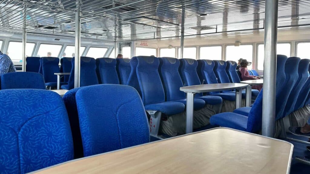 interior of a ferry with blue seats arranged throughout