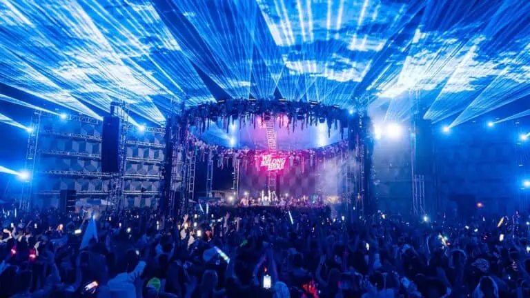 a round 360 stage with wild blue lights at a music festival
