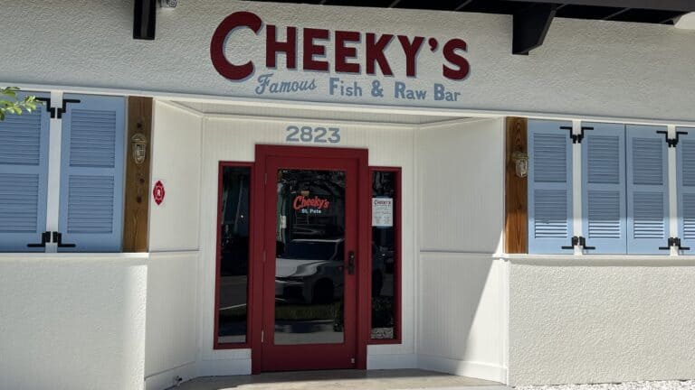 front of white restaurant with Cheeky's painted over the door.