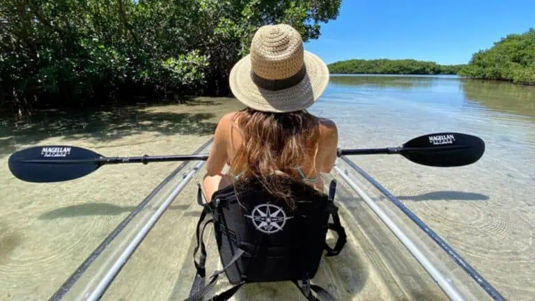 woman on a clear kayak on the water