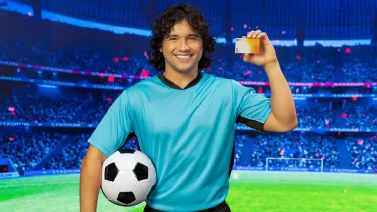 A soccer player smiling with a credit card