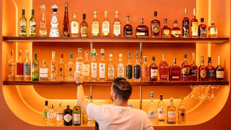 Bartender getting a drink in front of an orange bar