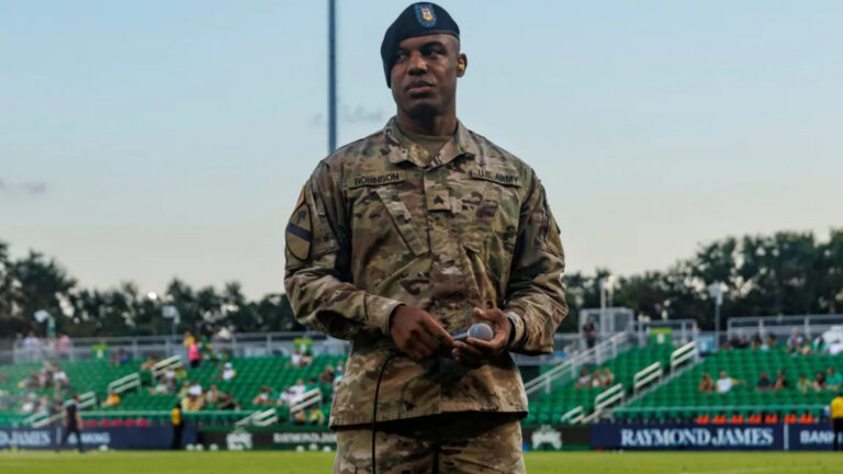 Soldier standing on a soccer pitch