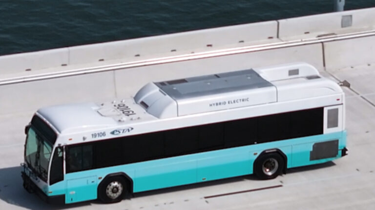 A bus riding by the water