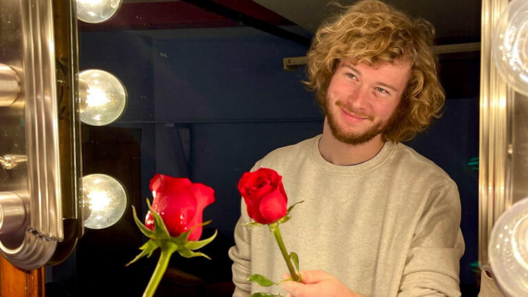 Man with a rose, looking into a mirror