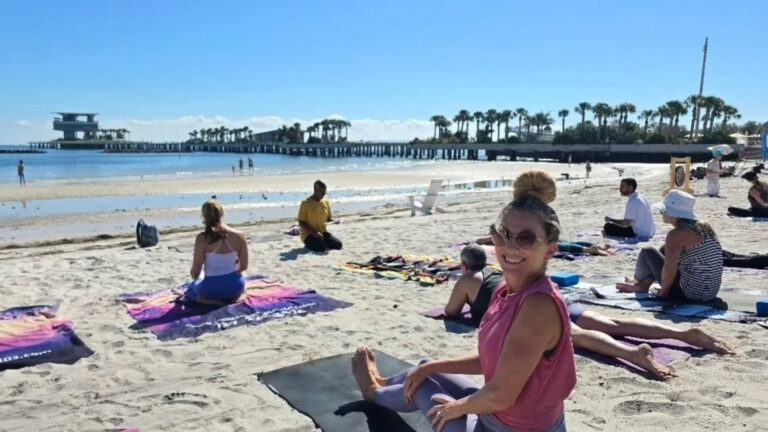 People doing yoga on the beach at St. Pete Yoga Fest