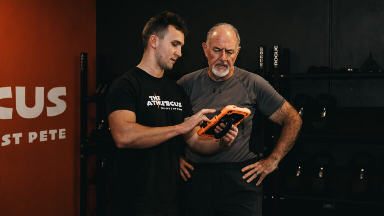Coach reviewing nutrition with a member at The Athleticus, a private personal training studio in St. Pete