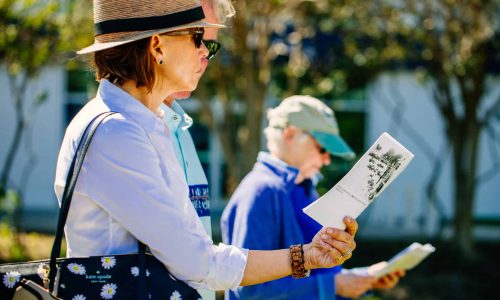 A tour guest looks at the map handouts during a walking tour